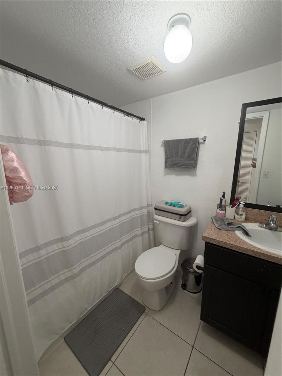 2536 Northwest 24th Street, Unit 3F Miami, FL 33142 - Photo 7 of 17 a bathroom with a toilet a sink and mirror