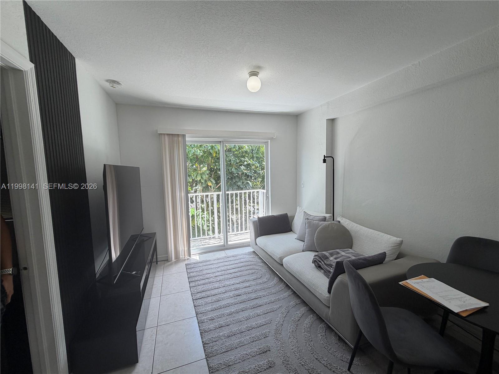 2536 Northwest 24th Street, Unit 3F Miami, FL 33142 - Photo 8 of 17 a living room with furniture and a window