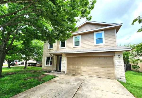 a front view of a house with a yard and trees