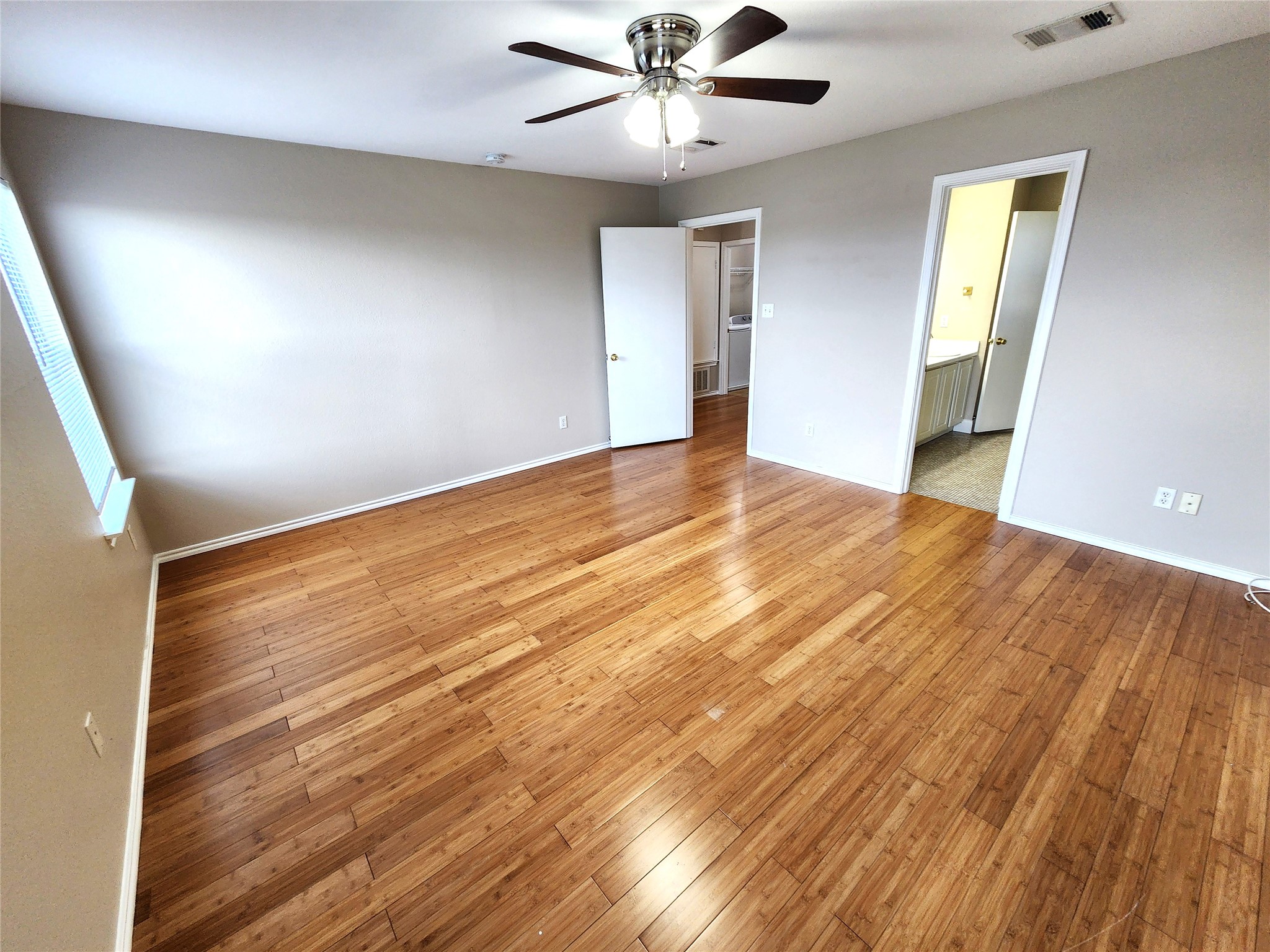 933 Meadow Ridge Loop Georgetown, TX 78626 - Photo 18 of 28 a view of an empty room with wooden floor and a ceiling fan