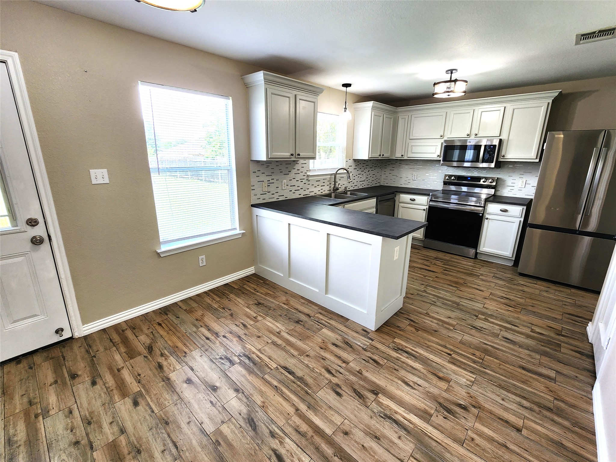 933 Meadow Ridge Loop Georgetown, TX 78626 - Photo 2 of 28 a kitchen with granite countertop a stove a sink and a refrigerator