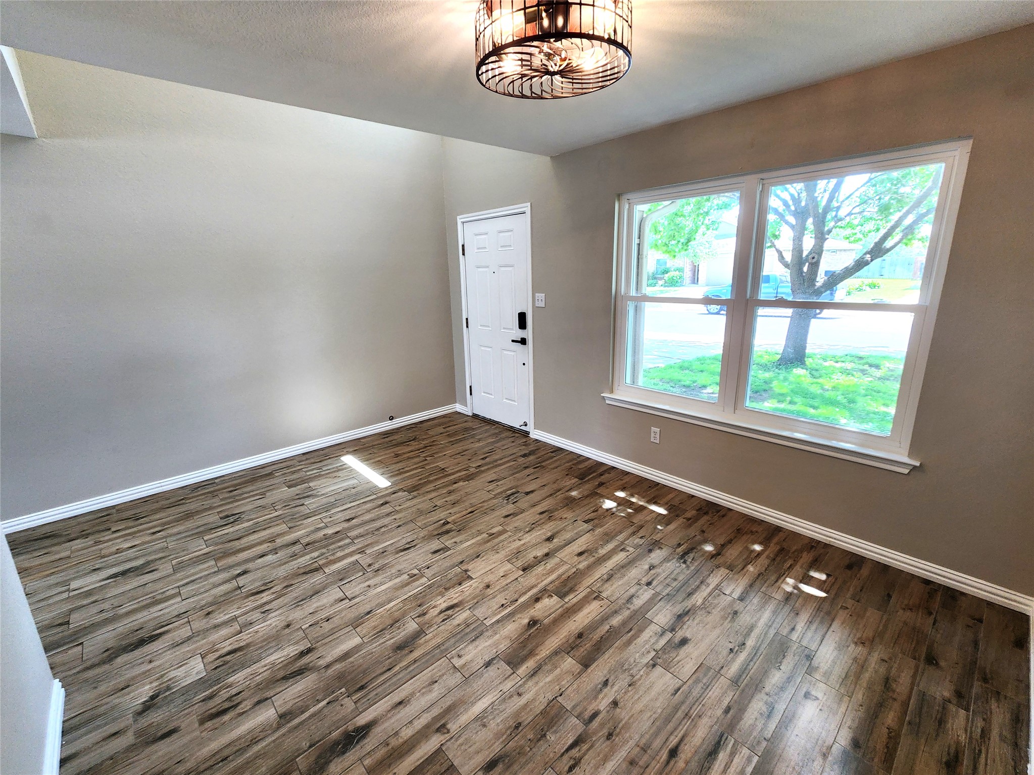 933 Meadow Ridge Loop Georgetown, TX 78626 - Photo 10 of 28 a view of an empty room with wooden floor and a window