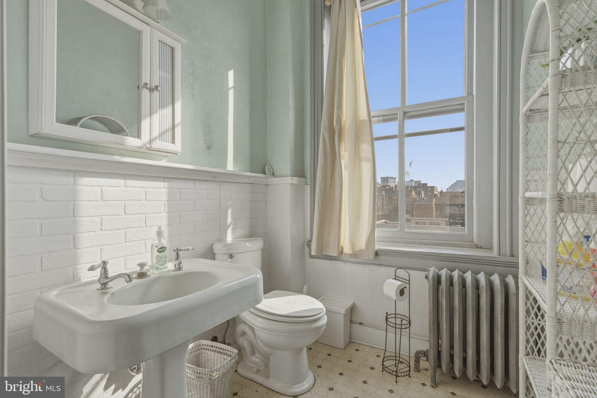 222 West Madison Street Baltimore, MD 21201 - Photo 26 of 40 a bathroom with a sink a toilet and a mirror