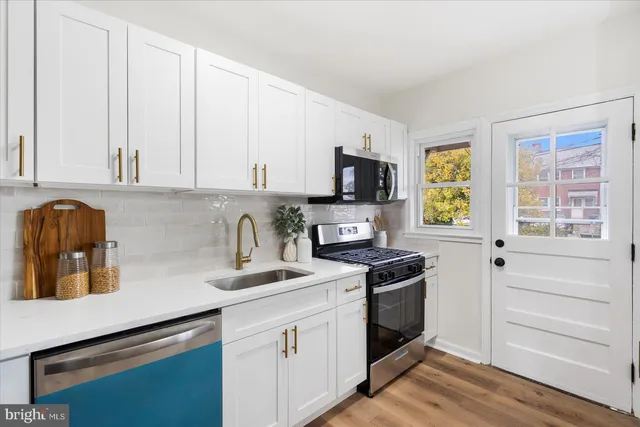 a kitchen with granite countertop white cabinets and appliances
