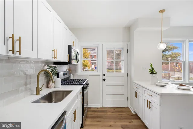 a kitchen with white cabinets sink and window