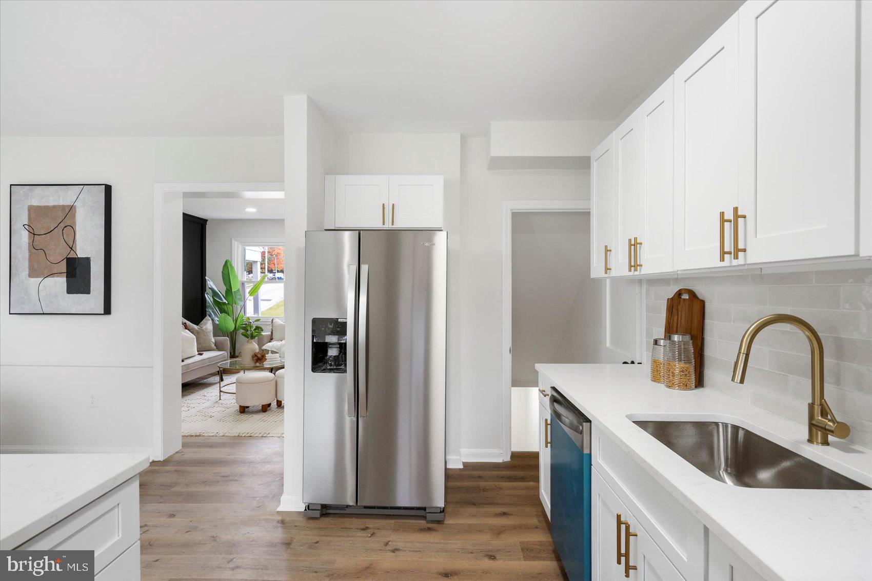 1656 Ramblewood Road Baltimore, MD 21239 - Photo 18 of 40 a kitchen with a refrigerator sink and white cabinets
