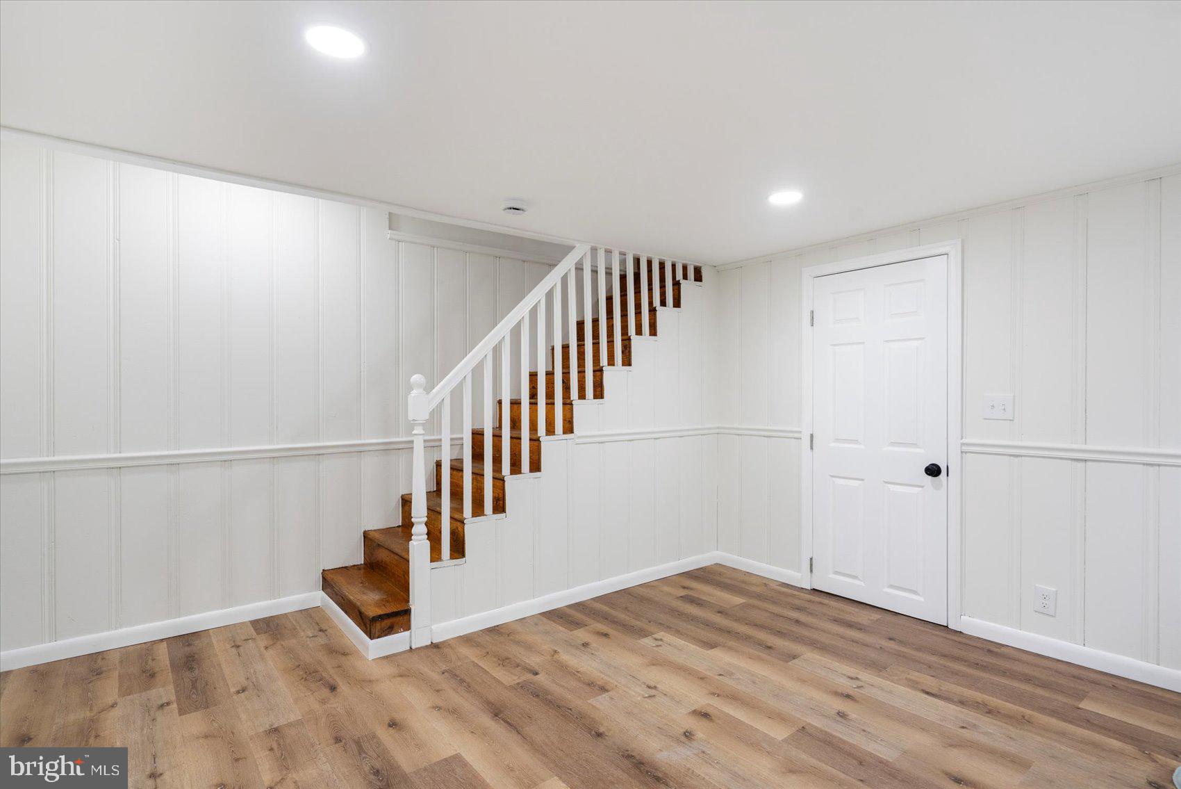 1656 Ramblewood Road Baltimore, MD 21239 - Photo 21 of 40 a view of an empty room with stairs and wooden floor