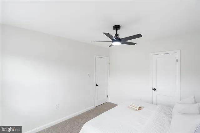 a bedroom with a bed and a ceiling fan