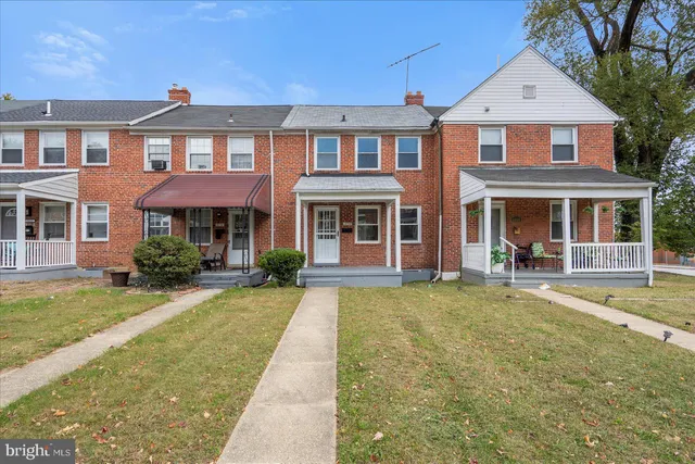 front view of a brick house with a yard