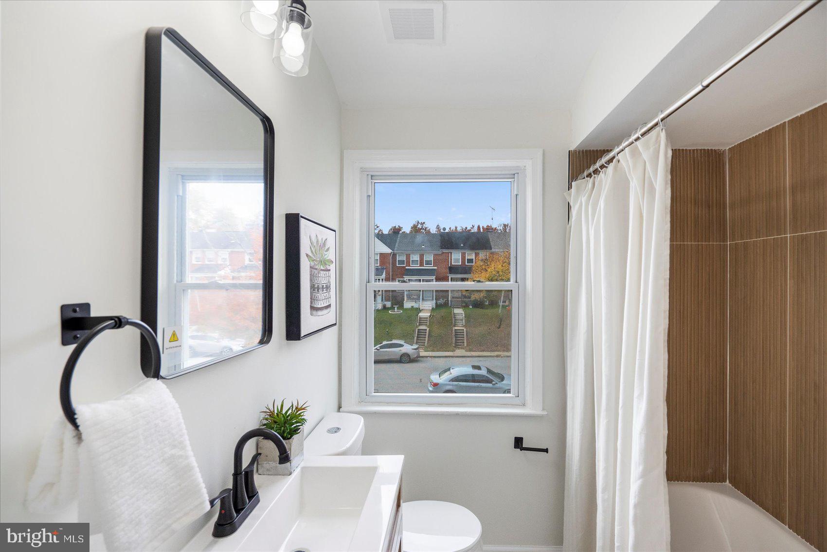 1656 Ramblewood Road Baltimore, MD 21239 - Photo 34 of 40 a bathroom with a shower sink and mirror