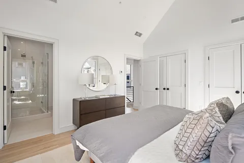 a bedroom with a bed a mirror and shower
