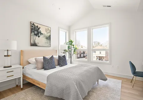 a bedroom with a bed and a large window