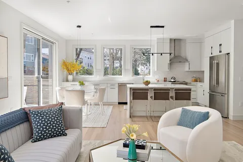 a living room with stainless steel appliances furniture and a large window