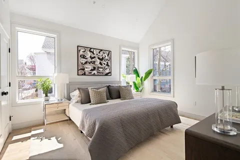 a bedroom with a bed table and a window