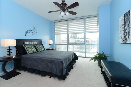 125 South Green Street, Unit 809A Chicago, IL 60607 - Photo 8 of 10 a bedroom with a bed lamp and a window
