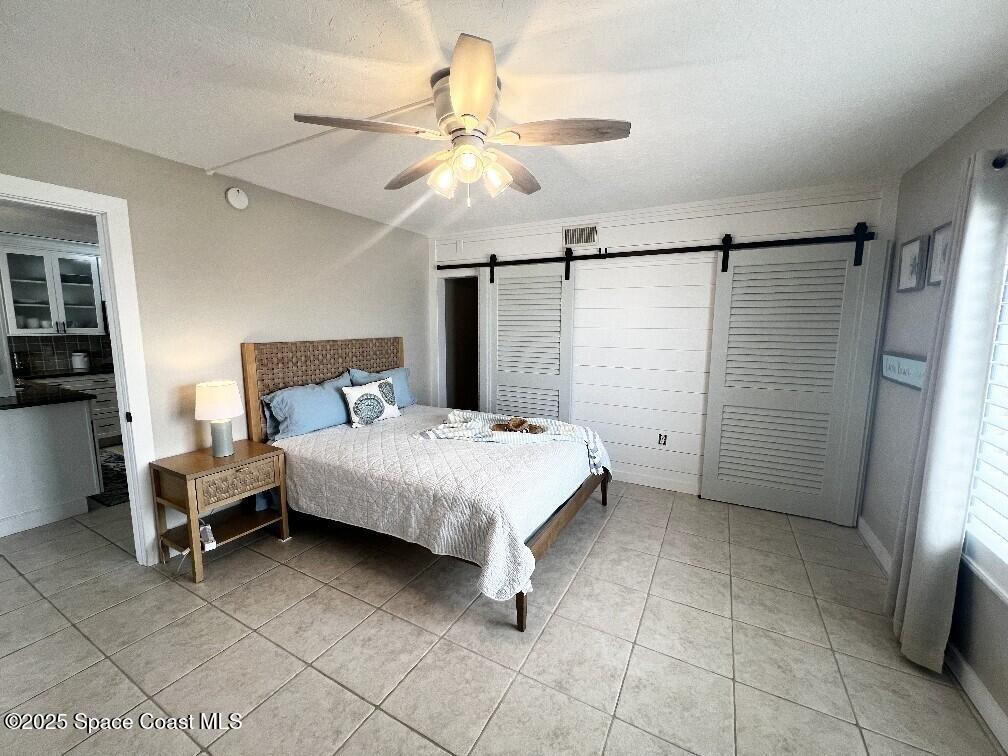 3060 North Atlantic Avenue, Unit 701 Cocoa Beach, FL 32931 - Photo 14 of 25 a bedroom with a bed and a chandelier