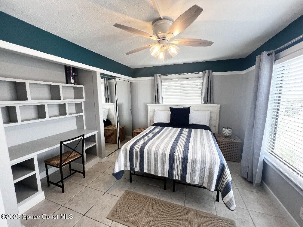 3060 North Atlantic Avenue, Unit 701 Cocoa Beach, FL 32931 - Photo 18 of 25 a bedroom with a bed and a chandelier
