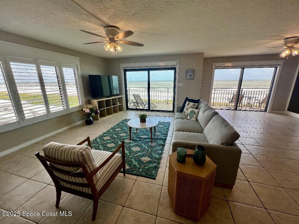 3060 North Atlantic Avenue, Unit 701 Cocoa Beach, FL 32931 - Photo 3 of 25 a living room with furniture and a large window
