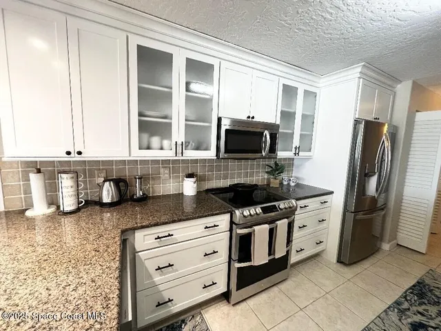 a kitchen with stainless steel appliances granite countertop a sink and a stove