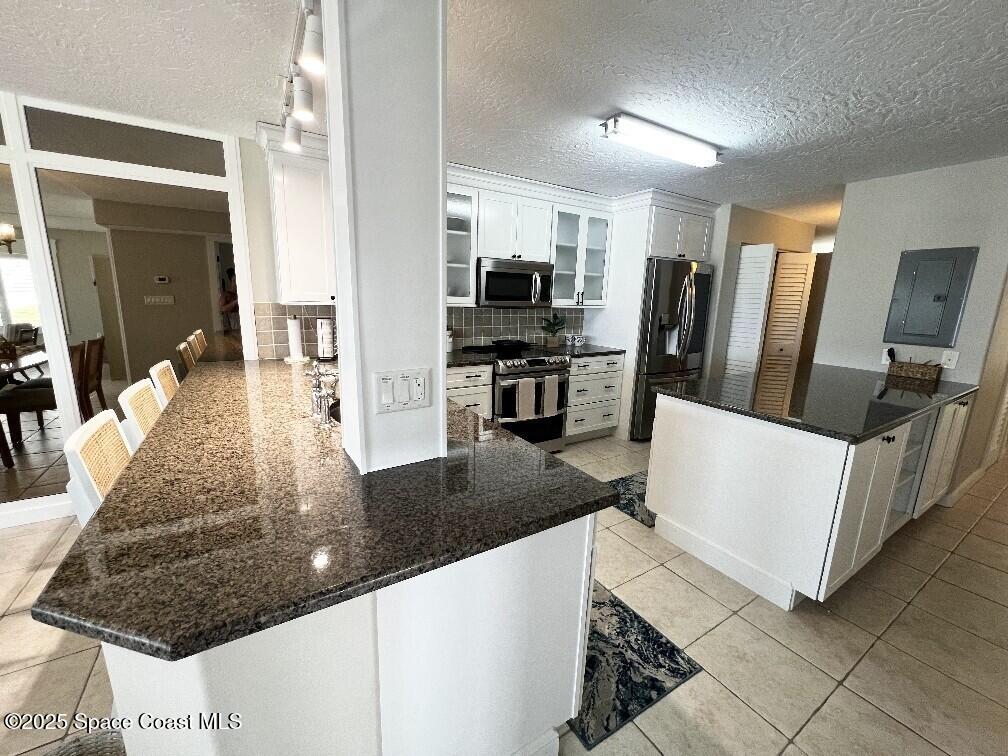 3060 North Atlantic Avenue, Unit 701 Cocoa Beach, FL 32931 - Photo 8 of 25 a kitchen with stainless steel appliances granite countertop a sink and a stove