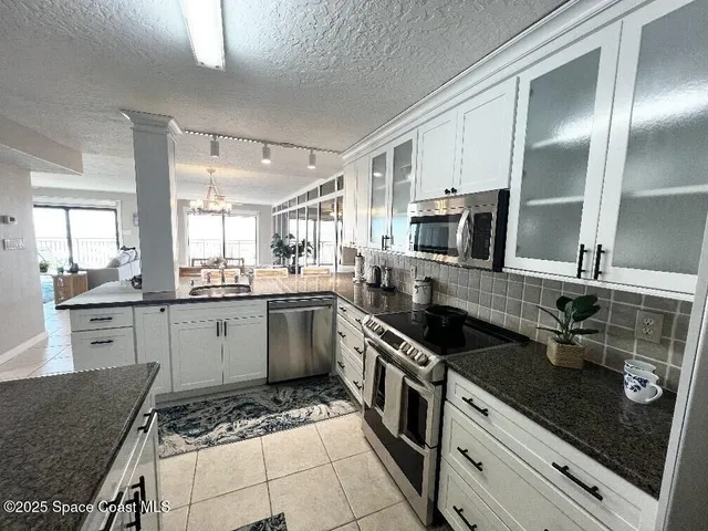 a kitchen with stainless steel appliances granite countertop a refrigerator and a sink