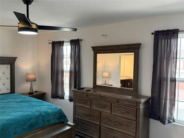 a bedroom with a bed and a mirror on dresser