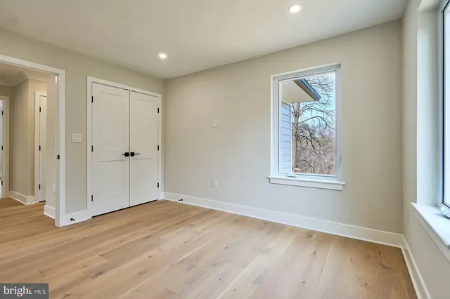 an empty room with wooden floor and window