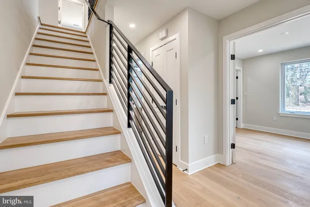 a view of a hallway with wooden floor and entryway