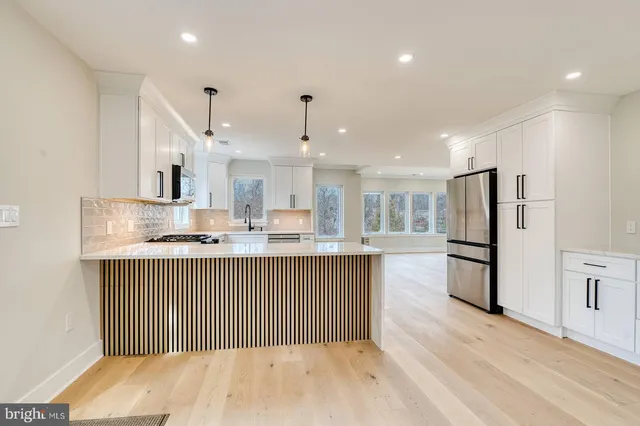 a kitchen with kitchen island a sink stainless steel appliances and cabinets