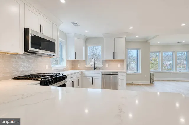 a kitchen with stainless steel appliances a stove sink microwave and cabinets