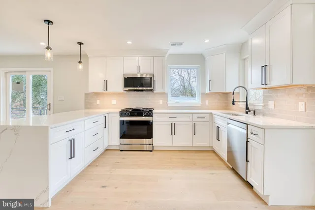 a kitchen with white cabinets sink and stainless steel appliances