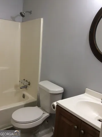 a view of an empty room with wooden floor and a fireplace