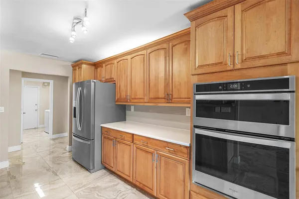 a kitchen with stainless steel appliances granite countertop a refrigerator stove and cabinets