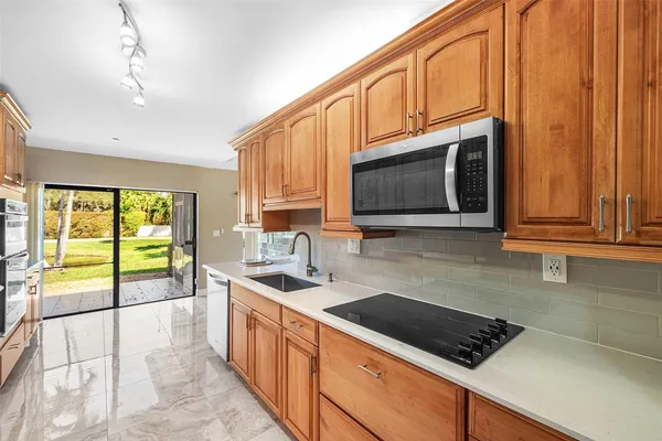 a kitchen with stainless steel appliances a stove sink microwave and cabinets