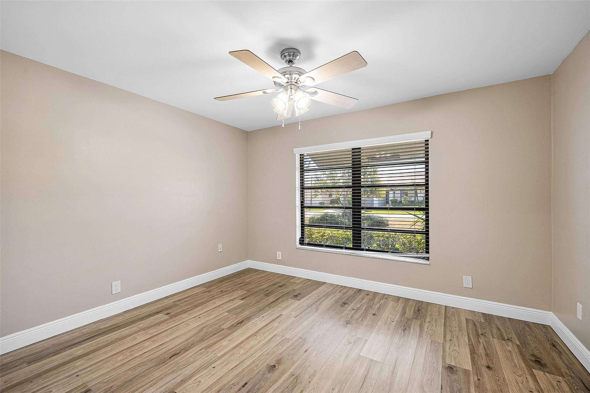 6191 Petaluma Drive Boca Raton, FL 33433 - Photo 19 of 36 an empty room with wooden floor chandelier fan and windows