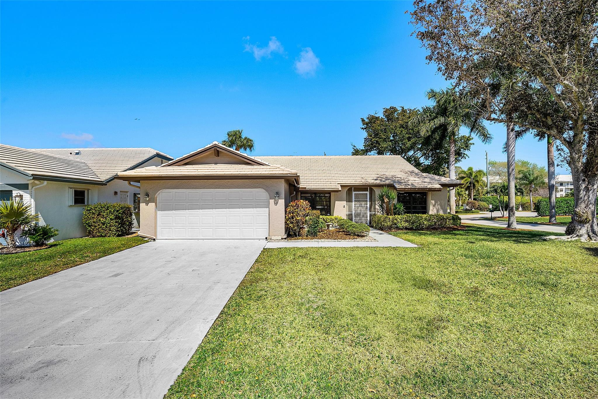 6191 Petaluma Drive Boca Raton, FL 33433 - Photo 2 of 36 a front view of a house with yard and green space