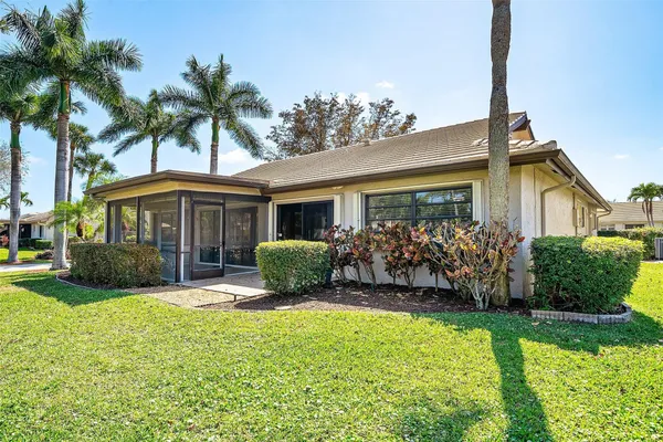 a front view of a house with a yard and potted plants