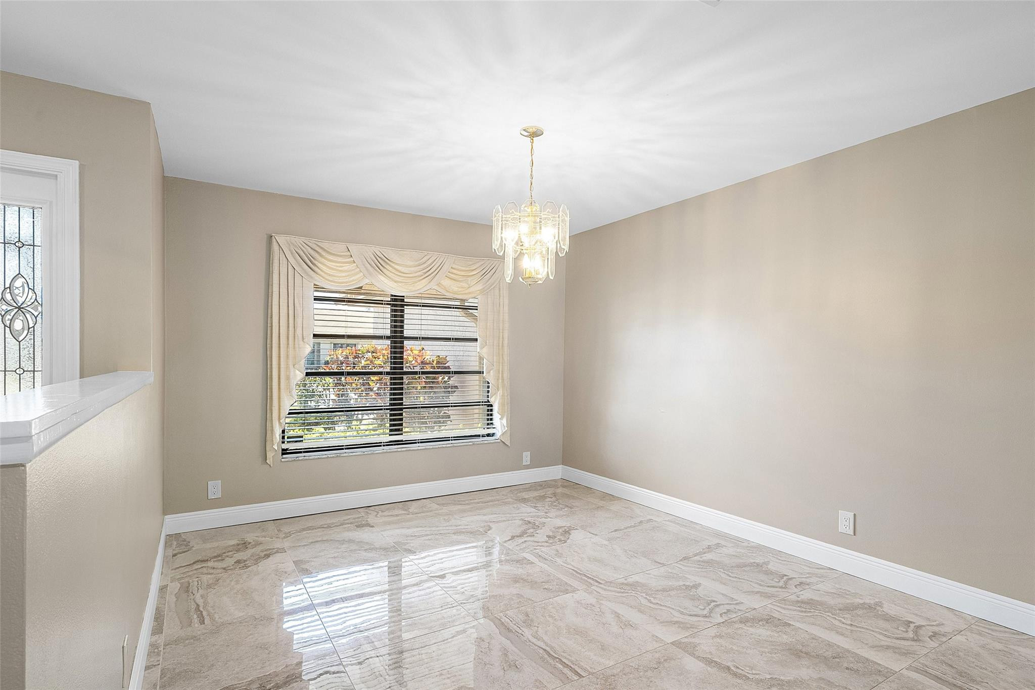 6191 Petaluma Drive Boca Raton, FL 33433 - Photo 7 of 36 an empty room with windows and chandelier fan