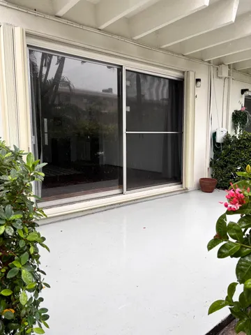a view of a glass door with a potted plant on the side house