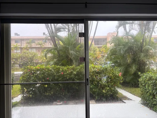 a view of a glass door with a yard from a window