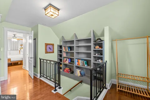 a view of a hallway with wooden floor and furniture