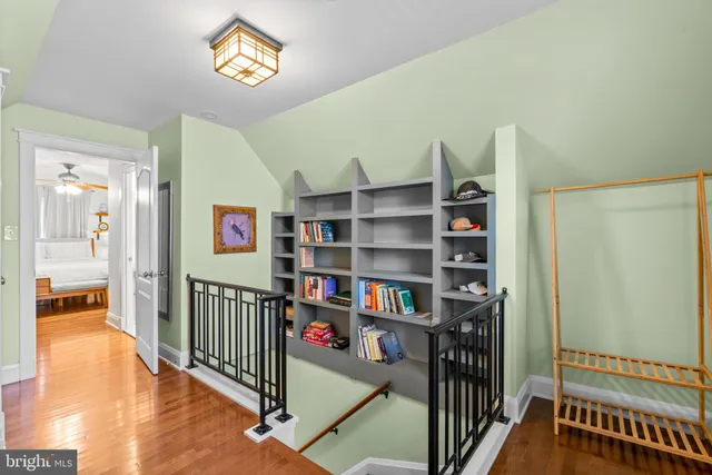 a view of a hallway with wooden floor and furniture