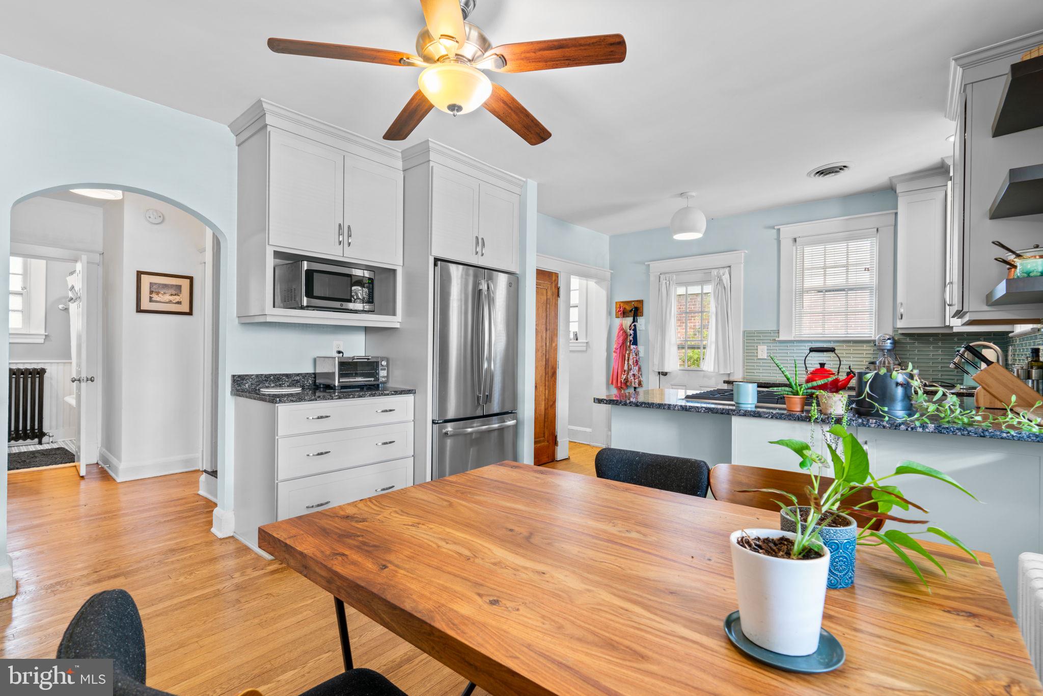 664 Regester Avenue Baltimore, MD 21212 - Photo 2 of 42 a kitchen with stainless steel appliances kitchen island granite countertop a refrigerator a stove top oven a sink dishwasher and white cabinets with wooden floor