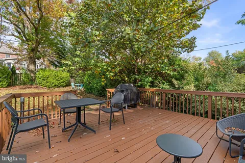 a balcony with wooden floor table and chairs