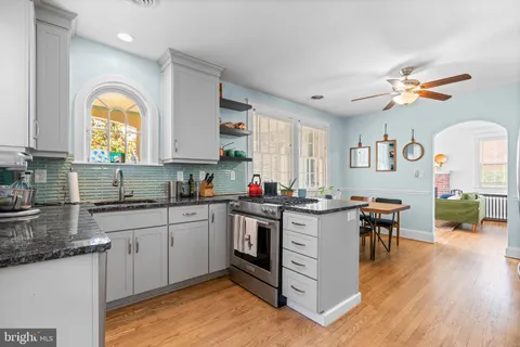 a kitchen with a stove a sink a dining table and chairs