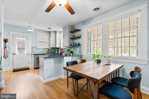 a kitchen with a table chairs refrigerator and cabinets