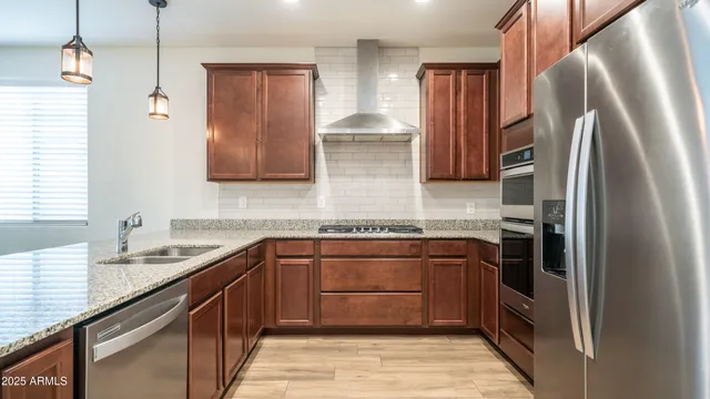 a kitchen with stainless steel appliances granite countertop a refrigerator and a sink
