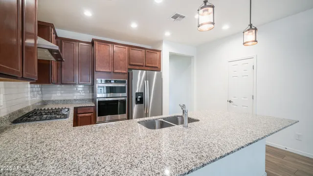 a kitchen with stainless steel appliances granite countertop a sink refrigerator and microwave