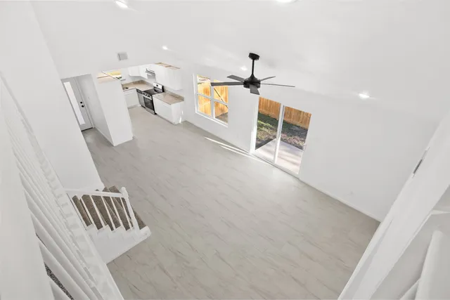 a view of stairs and an empty room with wooden floor