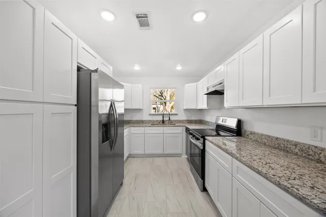 a kitchen with stainless steel appliances granite countertop a refrigerator sink and cabinets